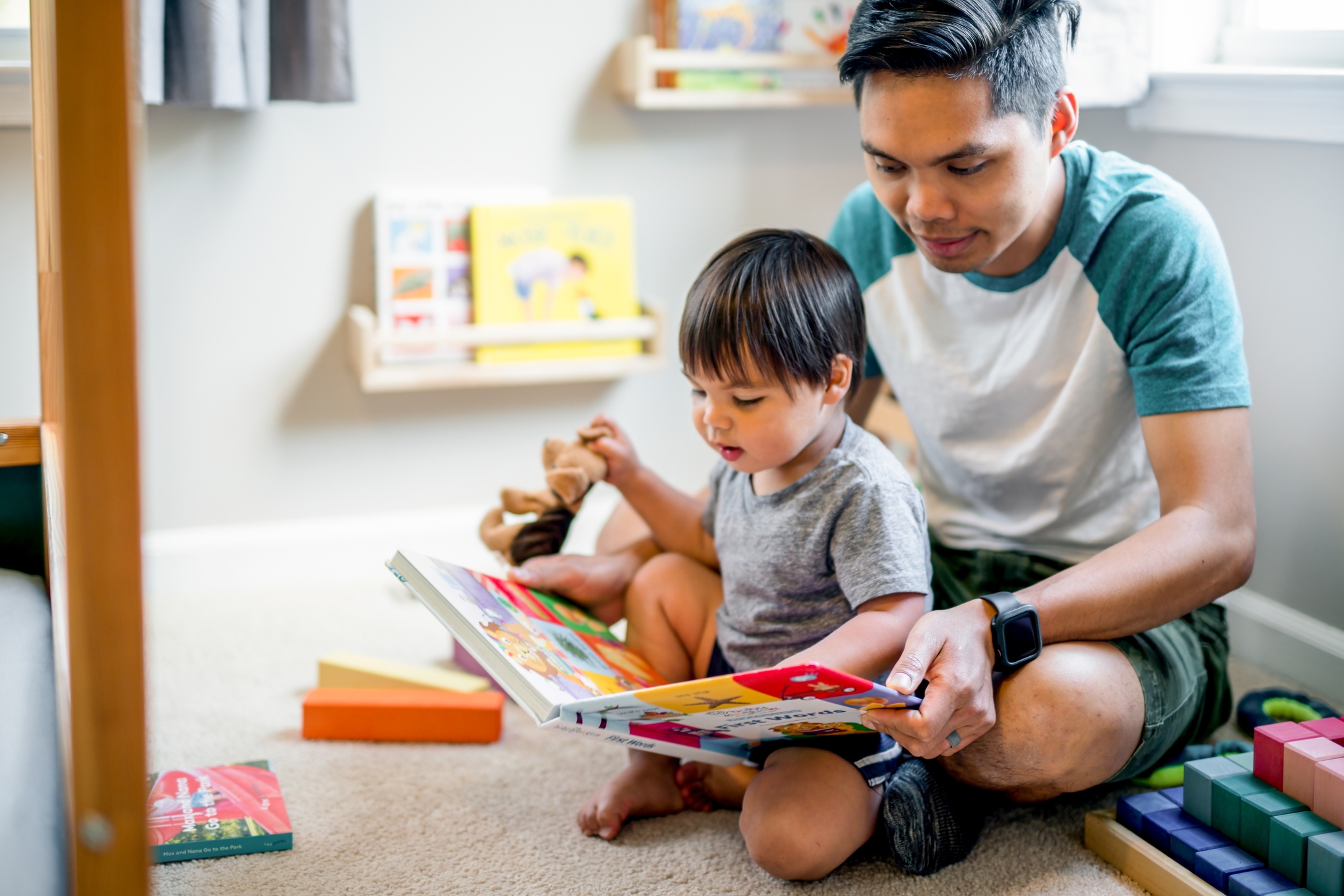 toddler daycare adjustment: Dad with toddler read books in daycare
